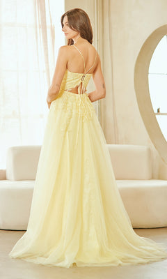 A woman stands indoors in the Amelia Couture 9079 Lace-Up Long Prom Ball Gown, featuring a lace-up back and subtle floral details, facing away from the camera.