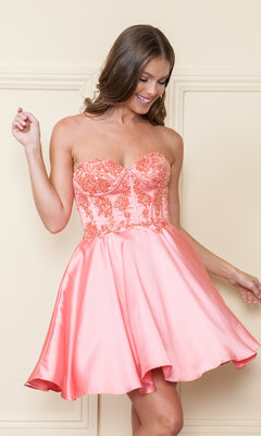 A woman stands against a cream wall in the Corset-Style Strapless Short Homecoming Dress 9084, featuring coral pink floral embroidered bodice and a flared satin skirt.