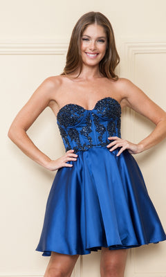 A woman smiles at the camera, modeling the Corset-Style Strapless Short Homecoming Dress 9084 in royal blue, featuring a beaded corset bodice and flared satin skirt.
