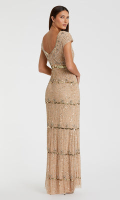 A woman faces away in a Mac Duggal 9089 Cap-Sleeve Beaded Formal Dress, floor-length with champagne sequins and bead embellishments.