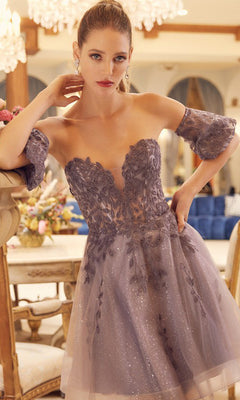 A woman wears the Bell-Sleeve Short Sweetheart Prom Dress 909, featuring floral embroidery and a delicate corset bodice, standing indoors with elegant decor in the background.