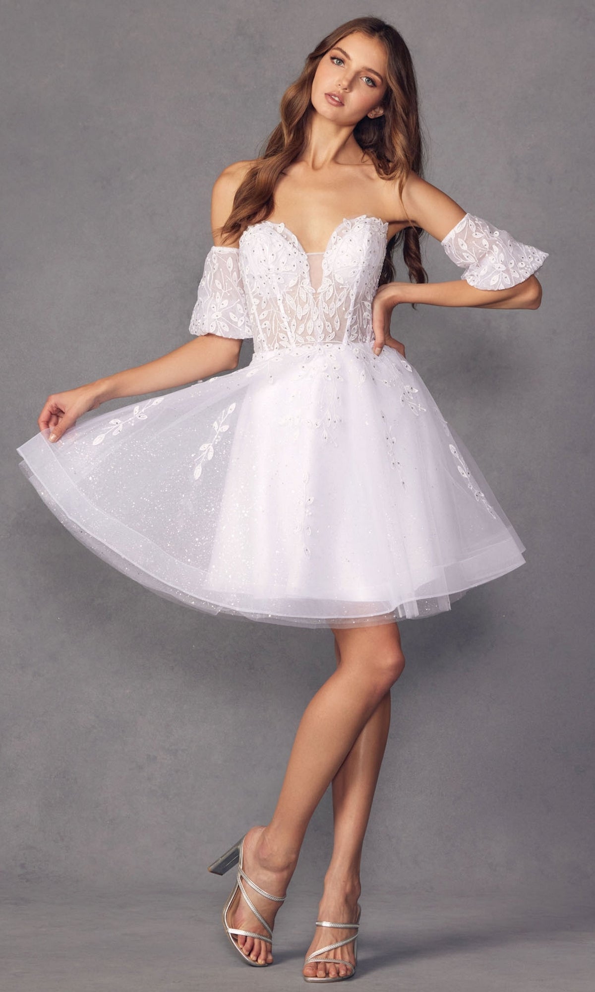 A woman wears the Bell-Sleeve Short Sweetheart Prom Dress 909—white, off-the-shoulder with a corset-style lace bodice and flared skirt—standing against a plain gray background.
