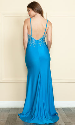 A woman stands facing away in the Poly USA 9120 Backless Long Jersey Prom Dress, featuring a turquoise hue, thin straps, beaded upper-back detail, and a subtle thigh-high slit.