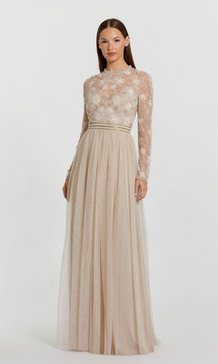A woman stands against a white background wearing the Mac Duggal 9132 Long Sleeve Vanilla Formal Gown, featuring sheer embroidered sleeves and a fitted, floral-embroidered bodice in a chic beige hue.