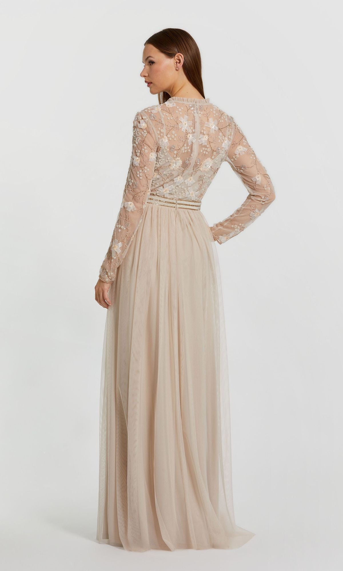 A woman models the Long Sleeve Vanilla Formal Gown: Mac Duggal 9132, featuring a beige sheer embroidered lace top and sleeves, shown from the back against a plain white background.