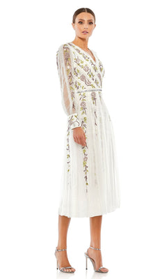 A woman poses against a plain white background in the "Knee Length Wedding Guest Dress 9133 by Mac Duggal," featuring white, long sleeves, a-line silhouette, floral embroidery, and silver high heels.