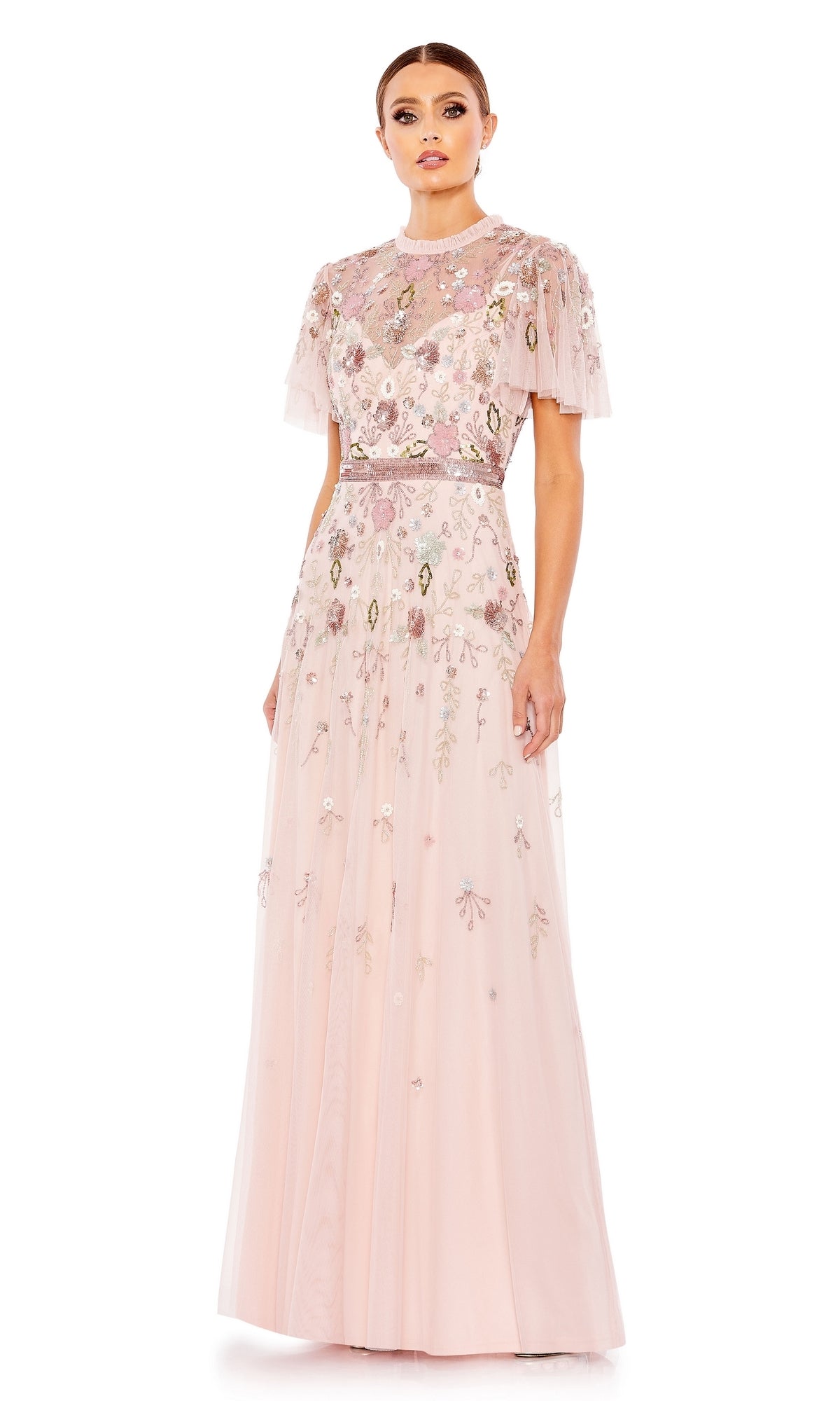 A woman models the Long Formal Dress 9136 by Mac Duggal, a floor-length pale pink A-line gown with beading, floral embroidery, sheer sweetheart neckline, and short sleeves, standing against a plain white background.