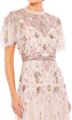 A woman wearing the Long Formal Dress 9136 by Mac Duggal, a light pink, short sleeve gown featuring a sheer sweetheart neckline and pastel floral embroidery.
