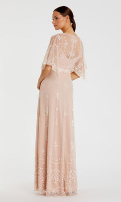 A woman stands facing away, wearing the Mac Duggal 9144 Long Pink Sequin Formal Dress with sheer embroidered fabric and flutter sleeves, posed against a plain white background.
