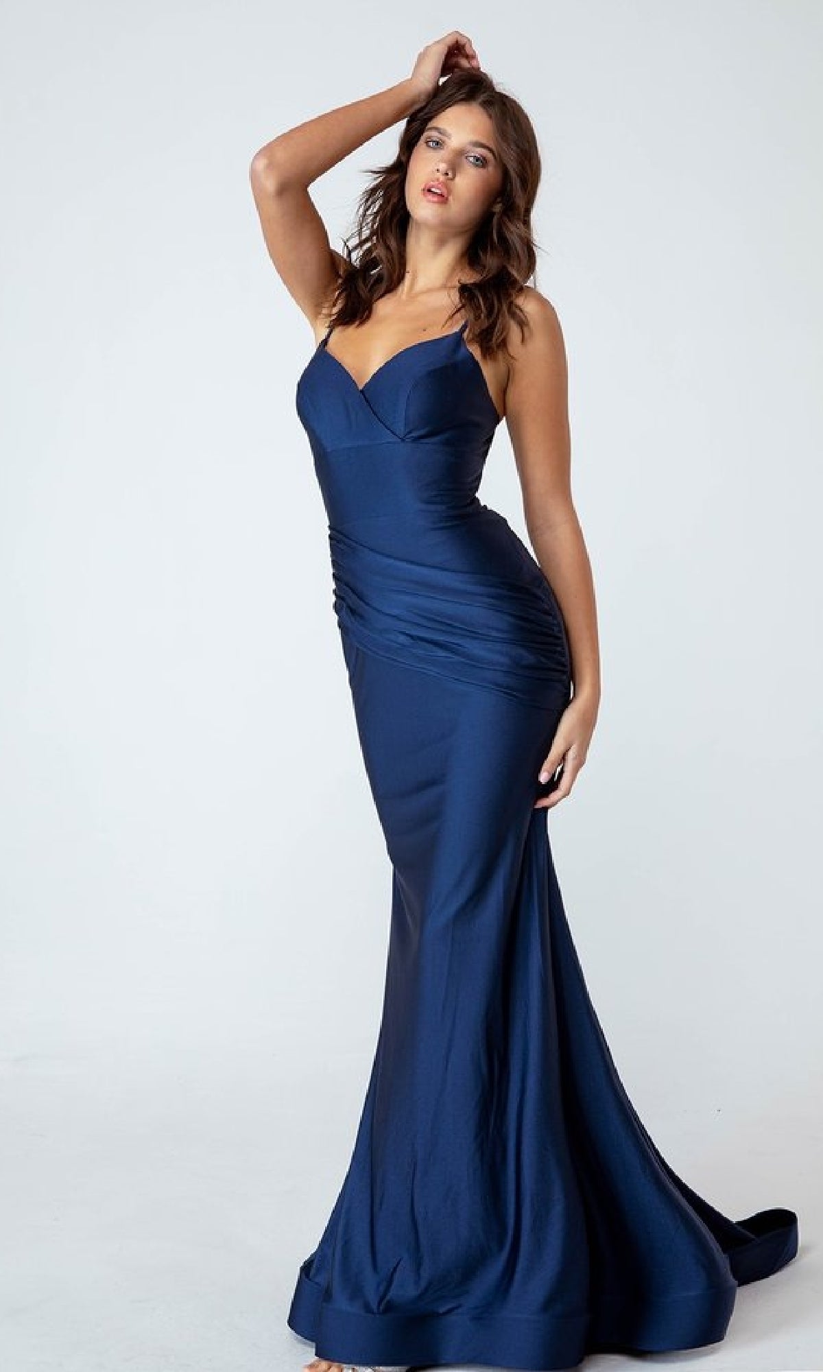 Woman wearing the Classic Long Mermaid Prom Dress: Eureka 9151, a fitted, floor-length, dark blue gown with spaghetti straps, posing against a light background.