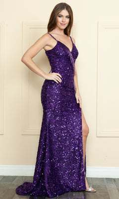 A woman poses against a beige wall in the purple Beaded-Fringe Long Sequin Prom Dress 9154, featuring a sleeveless design, floor length, sequins, and a thigh-high slit.