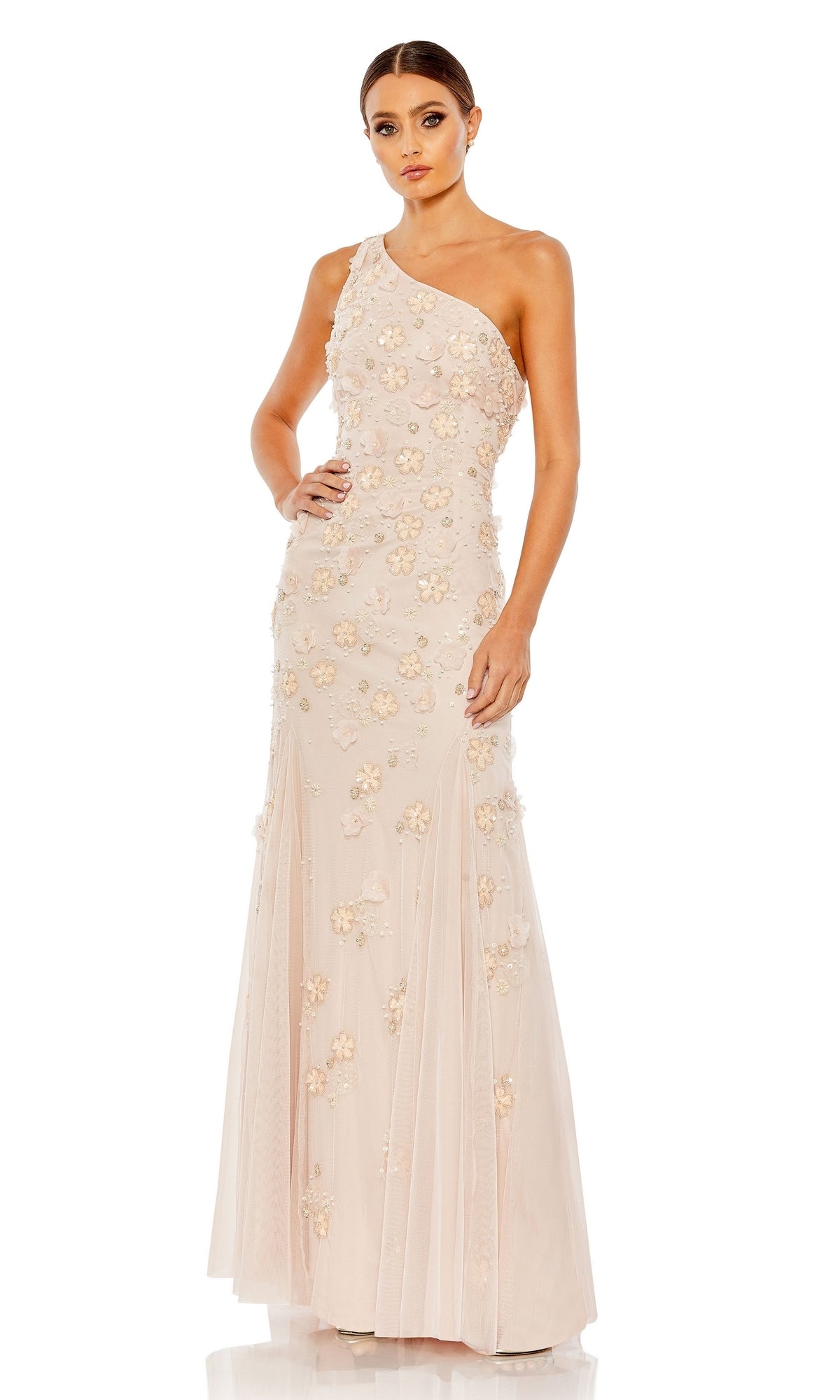 A woman models the Long Formal Dress 9168 by Mac Duggal—a blush pink, floor-length one-shoulder gown with floral appliqués—standing against a white background for an elegant, classic a-line look.
