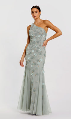 A woman stands against a plain light background wearing the Long Formal Dress 9168 by Mac Duggal, featuring a light blue one-shoulder design with floral appliqués and delicate bead embellishments.