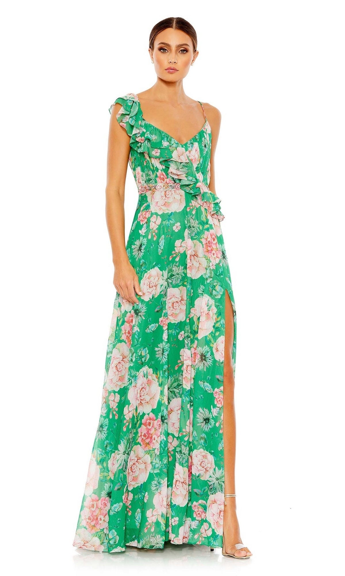Woman wears Mac Duggal 9175, a long green floral-print formal dress with ruffled details and side slit, paired with strappy heels against a white background—the perfect special-occasion look.