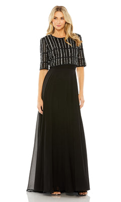 A woman stands facing forward in the Mac Duggal 9180 short sleeve long formal dress featuring a beaded crop top and flowing a-line skirt.