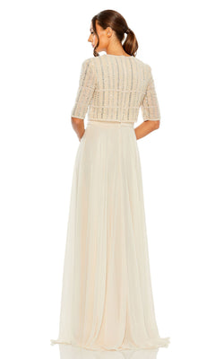 Woman standing with back to camera, wearing the Mac Duggal 9180 short sleeve long formal dress—a cream floor-length gown with a beaded crop top bodice and flowing A-line skirt.