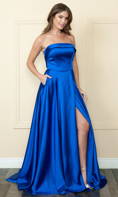 A woman stands indoors against a beige wall, wearing the Strapless Long A-Line Prom Dress with Pockets in royal blue satin, featuring a high side slit and lace-up back.