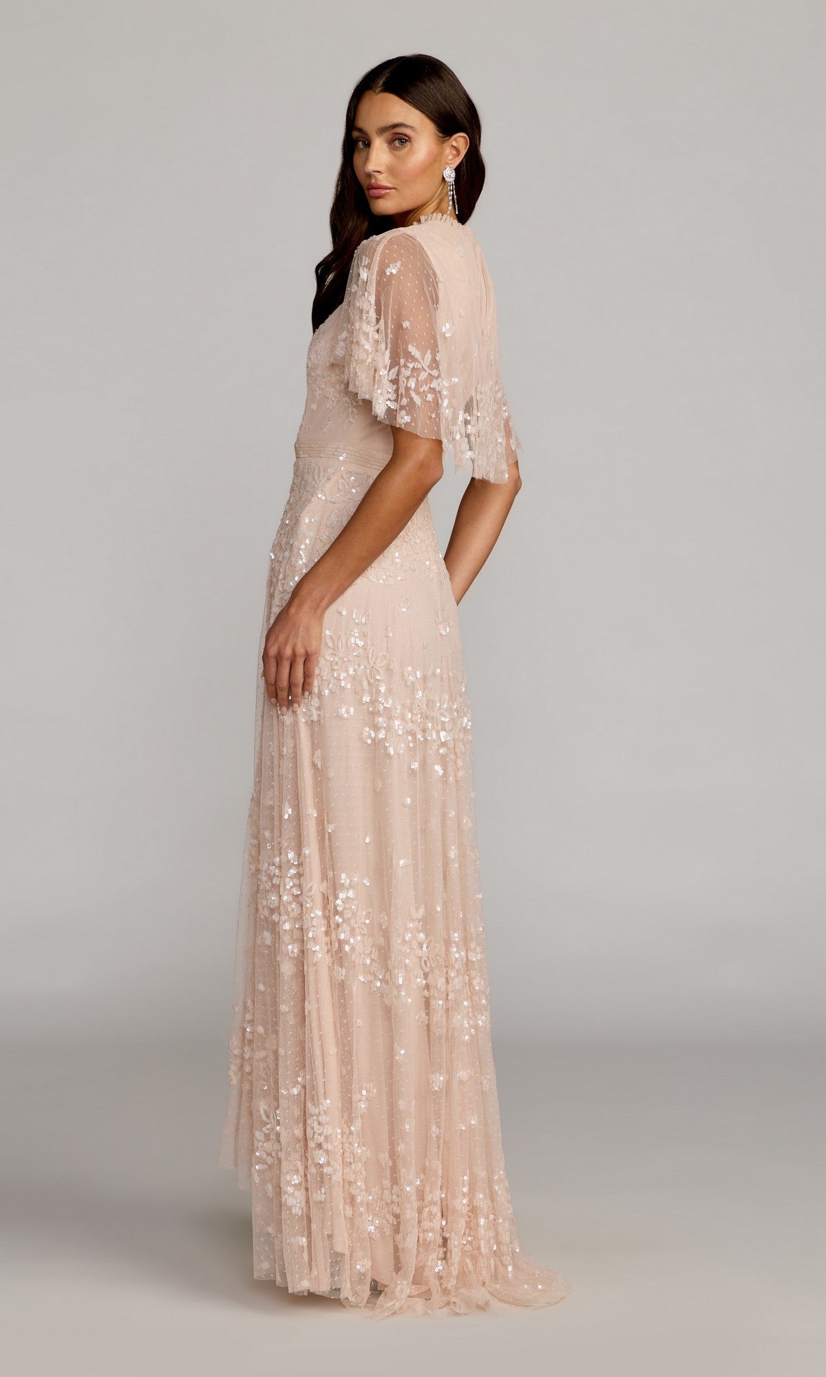 Woman wearing the Mac Duggal 9192 short-sleeve blue formal dress, floor-length with sheer sleeves, standing sideways against a plain background.