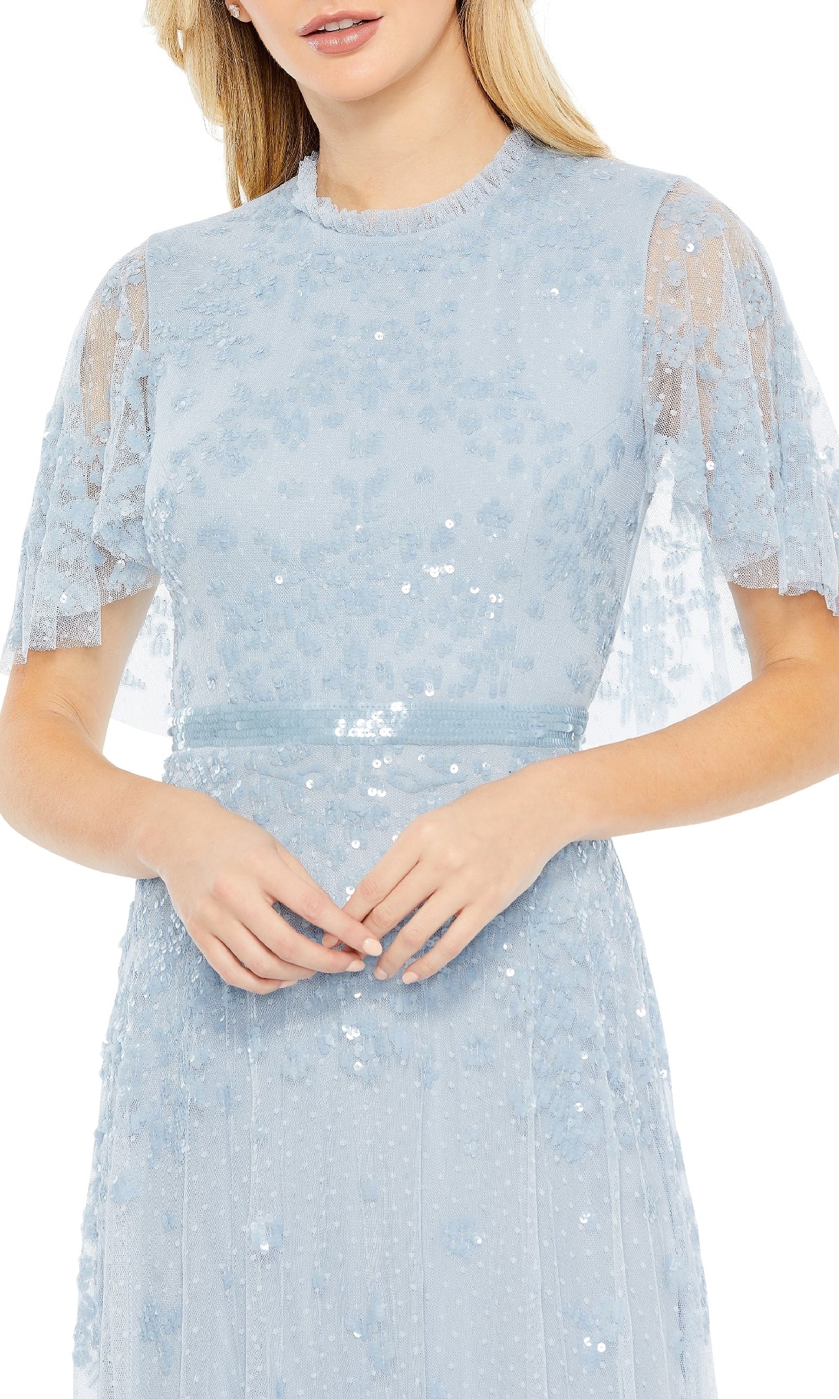 A woman wears the Mac Duggal 9192, a short-sleeve blue formal dress featuring sequin embellishments, a sheer overlay, and delicate floral details.