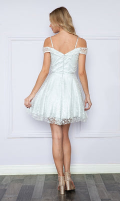 A woman faces away from the camera, standing on a wooden floor in the Cold-Shoulder Glitter Homecoming Dress 9198—a light blue, spaghetti strap party dress with a flared A-line skirt.