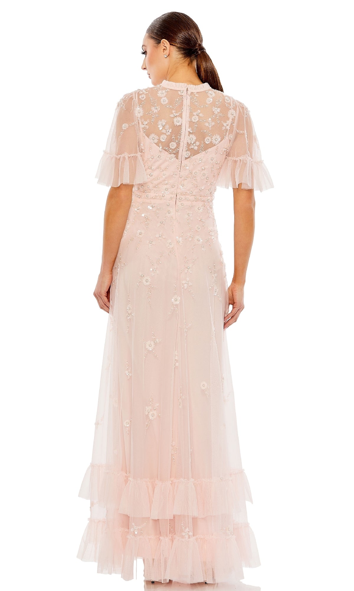 Woman wearing the Mac Duggal 9199 Short Sleeve Beaded Formal Gown, featuring floral embroidery, sheer sleeves, and ruffle details, shown from the back.