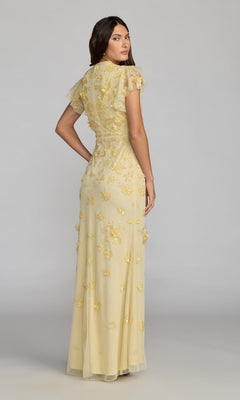 A woman stands against a plain background in the Beaded Periwinkle Formal Gown—Mac Duggal 9206—a floor-length, short-sleeved dress with floral embroidery, offering a graceful choice for a mother of the bride.