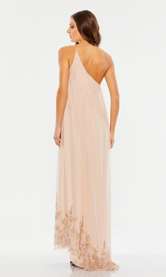 A woman stands with her back to the camera, wearing the Mac Duggal 9218 long formal dress—a light pink, one-shoulder gown featuring gold floral embroidery at the hem and a flowing chiffon overlay—set against a plain white background.