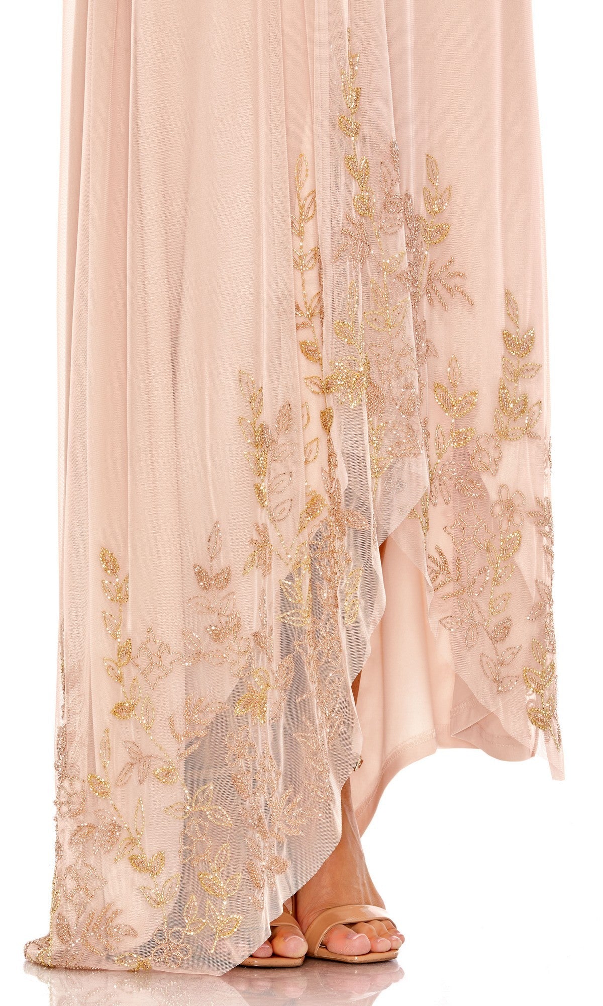A person wearing the Mac Duggal 9218 long formal dress—a light pink, floor-length, one-shoulder gown featuring gold embroidered floral patterns and a delicate chiffon overlay—paired with open-toed nude heels.