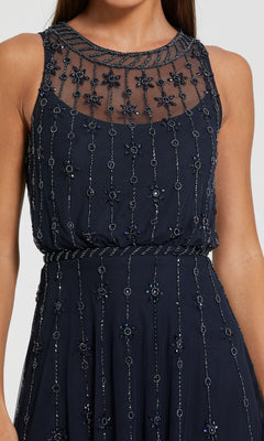 A woman wears the Mac Duggal 9222 Blue Midi Wedding Guest Dress, featuring a sleeveless design, navy blue color, sheer beaded neckline, and floral bead embellishments—an elegant choice for weddings.