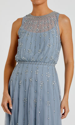A woman wearing the Mac Duggal 9222 Midi Wedding Guest Dress, a sleeveless light blue mesh dress with beaded floral embellishments and a sheer neckline.