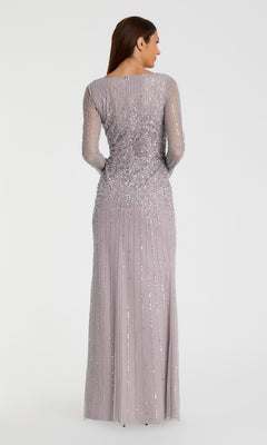 A woman faces away, modeling the Mac Duggal 9226 Long Sleeve Sequin Formal Gown—a floor-length, light purple evening dress with bead embellishments—against a plain white background.