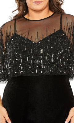 A woman wearing the Mac Duggal 9228 Long Plus-Size Formal Dress—a black gown with a v-neckline, sheer beaded overlay, and sequin-embellished bodice.