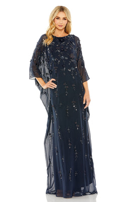 A woman poses gracefully with one hand on her hip, wearing the Mac Duggal 9242 Trapeze Embellished Formal Gown—a floor-length navy evening dress featuring sheer fabric, floral embroidery, and loose sleeves.