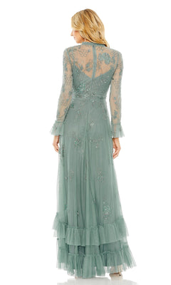 A woman is shown from the back against a white background wearing the Mac Duggal 9249 Long Formal Dress, a sheer, light green gown featuring beaded floral embellishments and ruffled sleeves.