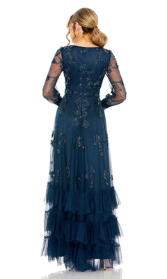 A woman stands with her back to the camera, wearing the Mac Duggal 9256—a long sleeve blue formal dress featuring sheer fabric, floral embroidery, and tiered ruffle layers.