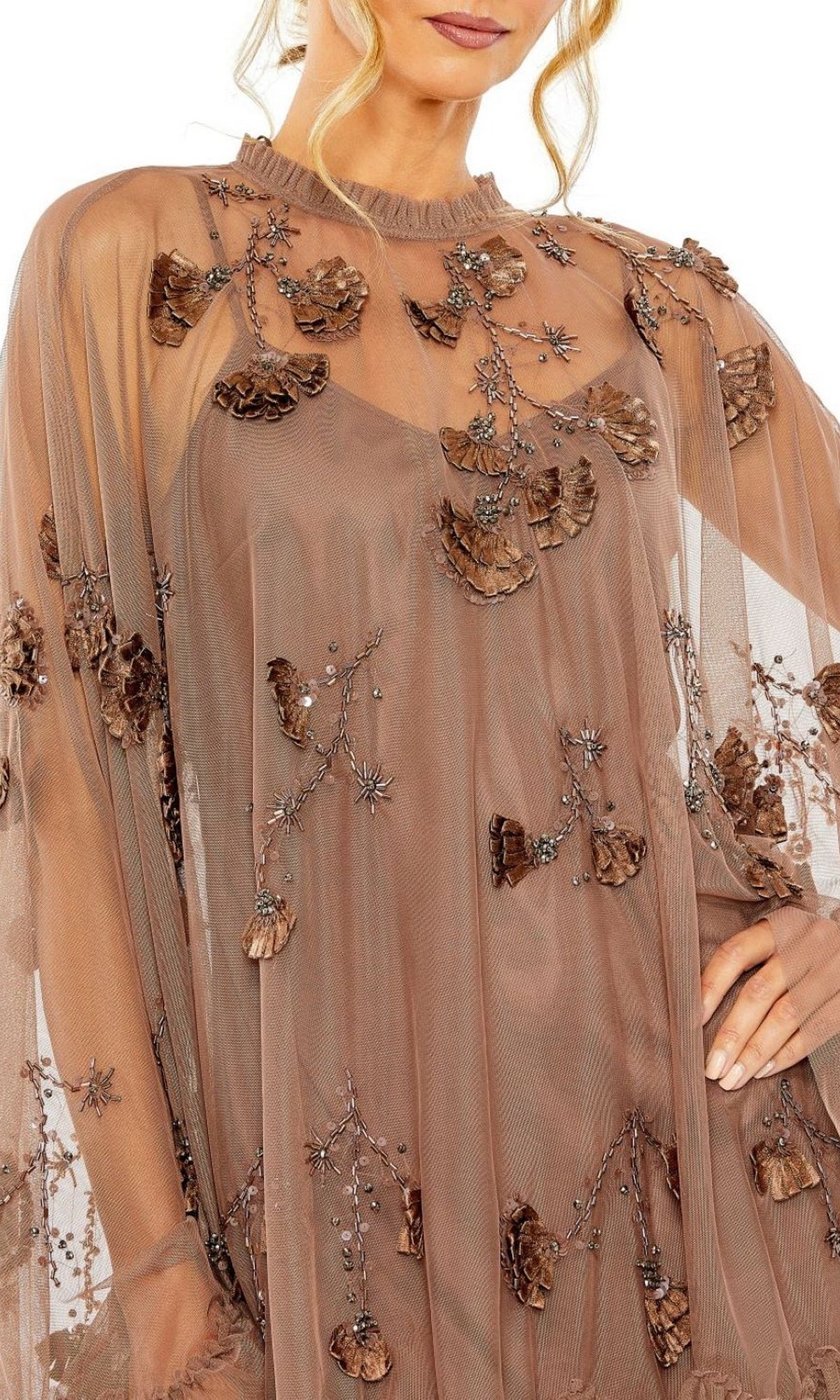 A woman models the Mac Duggal 9257 Long Sleeve Short Hoco Dress, featuring sheer brown fabric, 3D floral appliqué, beaded embellishments, and detailed bodice and sleeves for a stunning party look.