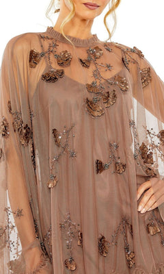 A woman models the Mac Duggal 9257 Long Sleeve Short Hoco Dress, featuring sheer brown fabric, 3D floral appliqué, beaded embellishments, and detailed bodice and sleeves for a stunning party look.