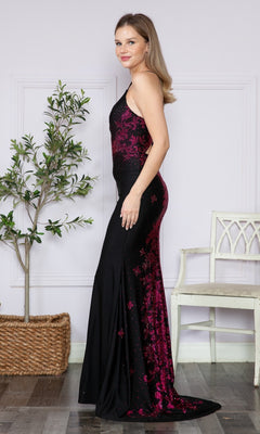 A woman stands sideways in a room, wearing the Contrasting Beads Long Black Prom Dress 9274 with magenta accents, near a potted plant and a white chair in the background.