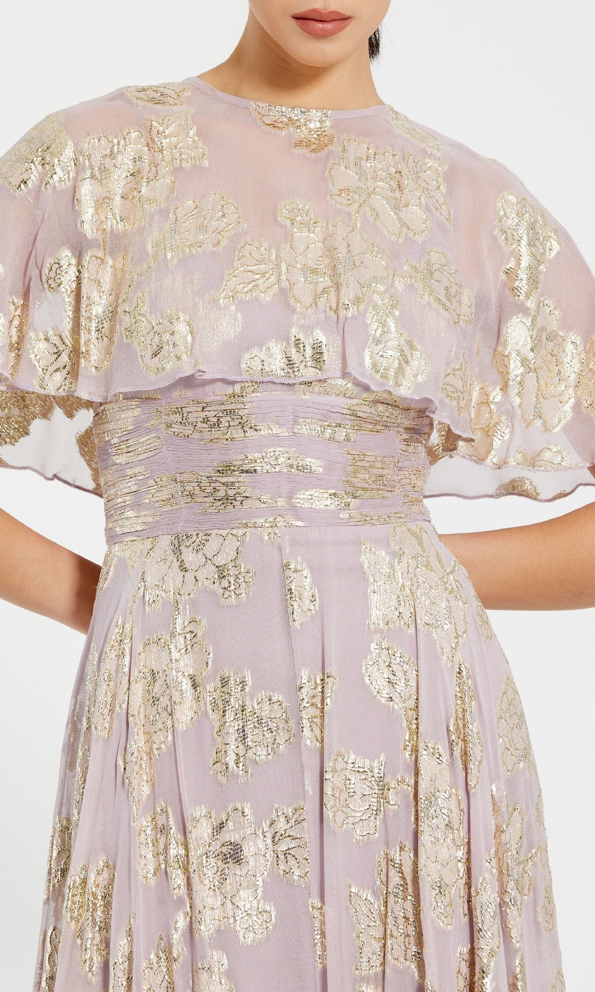 A woman wearing the Caped Long Lilac Formal Dress: Mac Duggal 9304—a lilac gown with gold floral metallic patterns and short, loose cape sleeves.