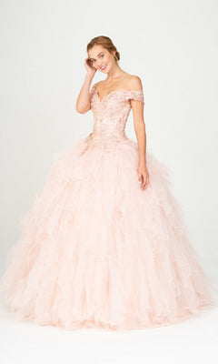 A woman poses against a white background in the Quinceanera Dress 9313 By Eureka, featuring a blush hue, beaded off-the-shoulder bodice, and a ruffled ball gown skirt.
