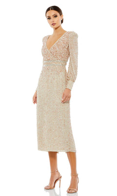 A woman models the Mac Duggal 93593 knee-length wedding guest dress, a beige, long-sleeve, sequin-embellished semi-formal outfit with a V-neckline and nude heels, standing against a white background.