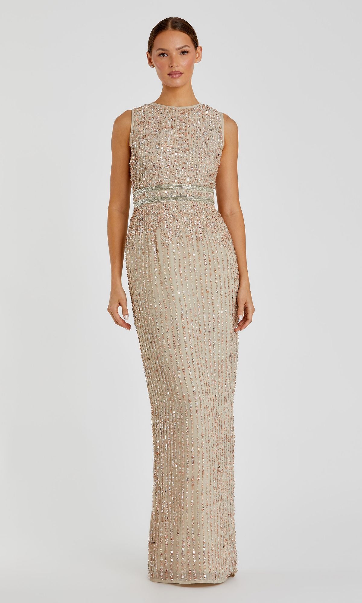 A woman wears the Sleeveless Sequin Formal Dress: Mac Duggal 93603, a floor-length beige evening gown with sparkling embellishments, standing against a plain light background.