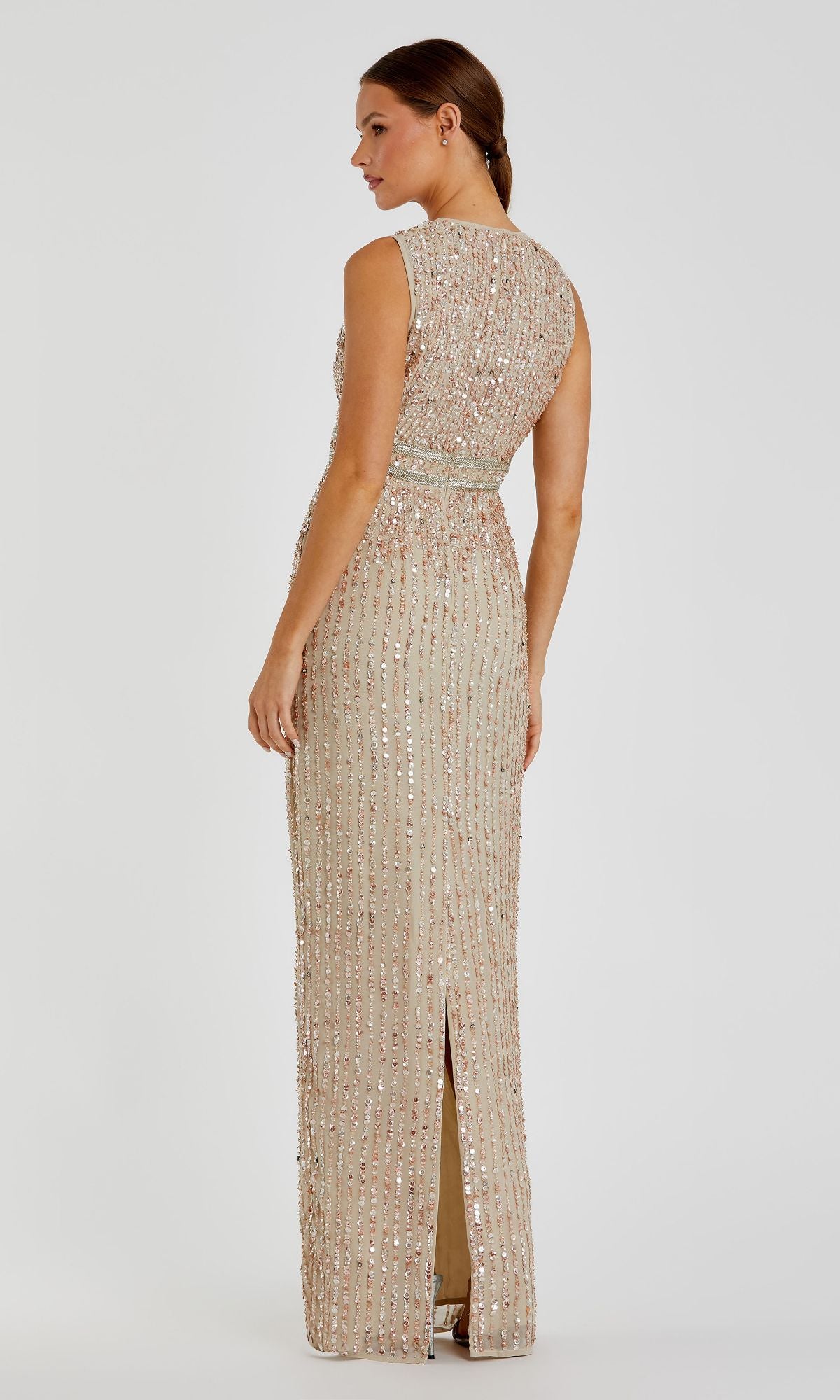 Woman stands facing away in the Mac Duggal 93603 Sleeveless Sequin Formal Dress—a floor-length beige gown with vertical sequin embellishments and a back slit.