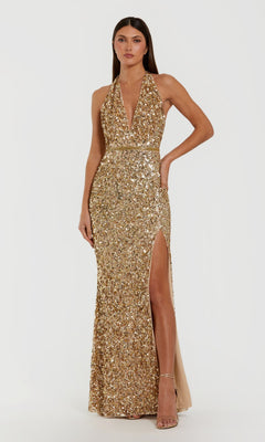 A woman stands against a plain white background wearing the Mac Duggal 93745 long formal dress in gold, featuring allover sequins, a halter neckline with a deep V front, fitted waist, and thigh-high slit, paired with nude heels.