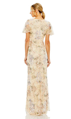 Woman with her back to the camera wears the Mac Duggal 93749 Short Sleeve Beaded Formal Dress, a floor-length gown featuring light floral sequins, fitted waist, and loose ponytail.