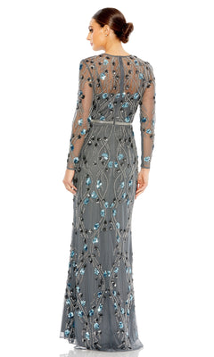 A woman faces away, wearing the Long Formal Dress 93772 by Mac Duggal—charcoal with long sleeves, sheer gray fabric, and blue and silver sequin embellishments. Her hair is in a low bun.