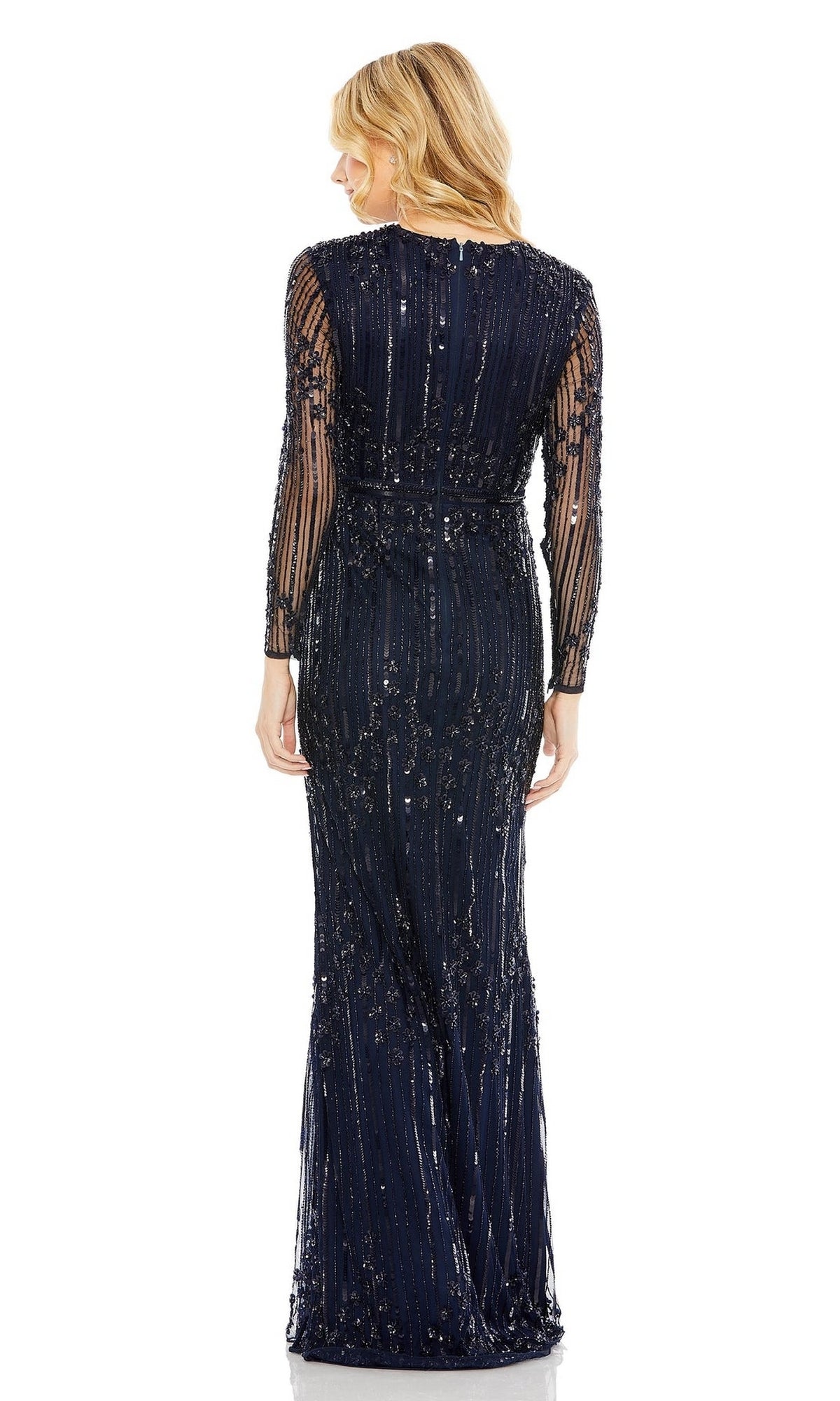 A woman with wavy blonde hair showcases the Mac Duggal 93781 Long Sleeve Beaded Formal Gown, a floor-length blue evening dress with sequin embellishments, modeled from the back against a white background.