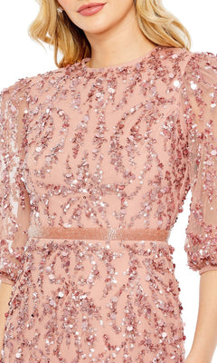A woman wears the Mac Duggal 93790 Long Sleeve Beaded Formal Dress in pink, adorned with sequins and beads, featuring semi-sheer puff sleeves and a fitted waist.