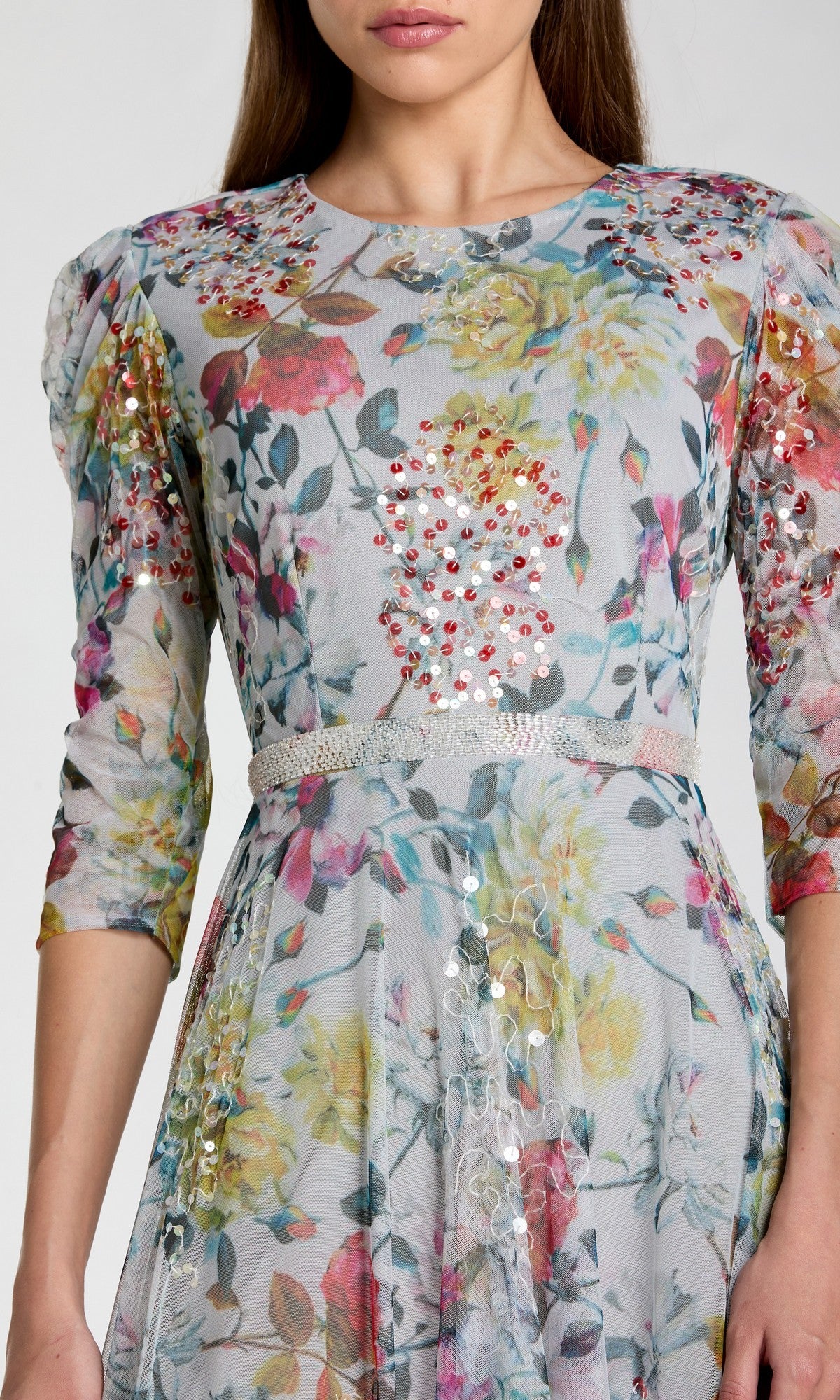 A woman wearing the Mac Duggal 93793 Tea-Length Party Dress, featuring light floral patterns, sequin embellishments, three-quarter sleeves, and a fitted waist—perfect as a chic choice for a wedding guest.