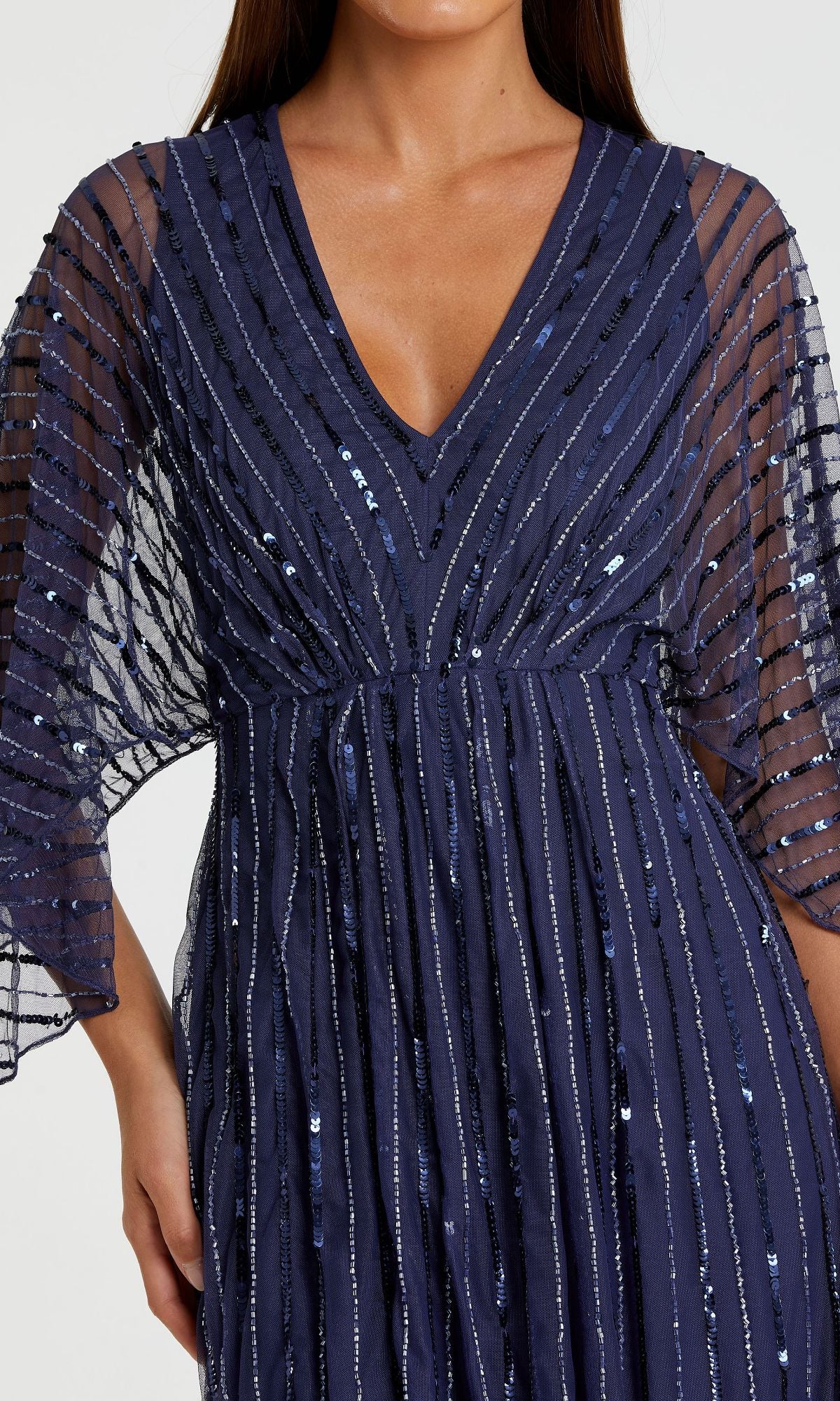 Woman in the Mac Duggal 93841 Long Sequin A-Line Formal Dress, featuring a navy blue hue, sheer elbow-length sleeves, and vertical sequin stripes for a dazzling look.